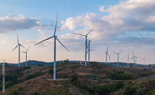 Wind turbine field with blue sky background at sunset. renewable energy