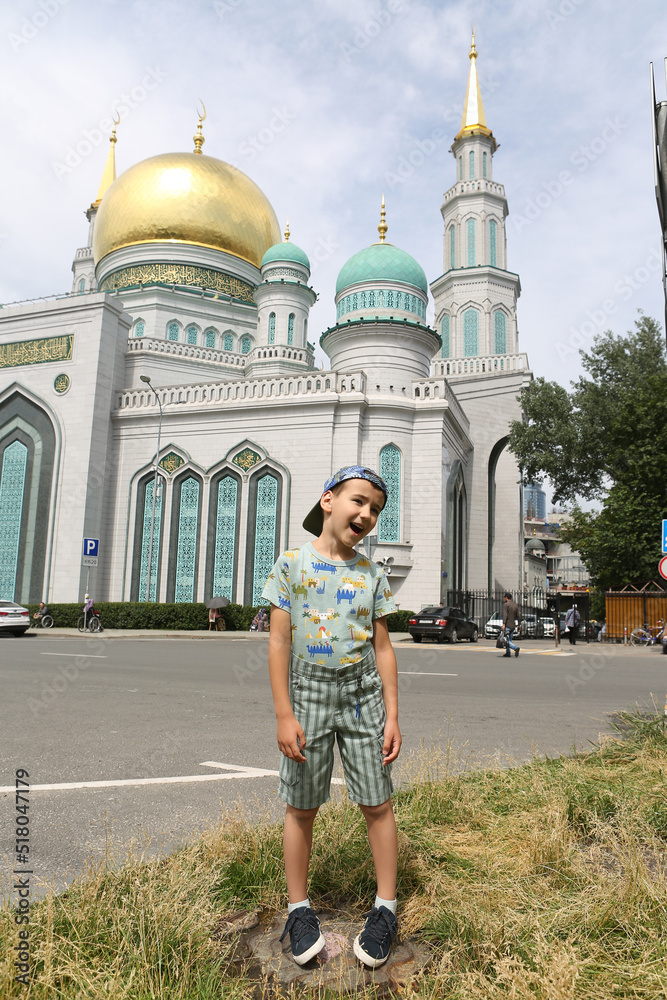 Obraz premium Tourist boy, cute child, fashion kid and Moscow Cathedral Mosque in Moscow city, Russia. Child and Moscow landmark, monument, sight, view. Islamic, muslim architecture