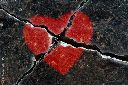 A broken red heart on a stone slab