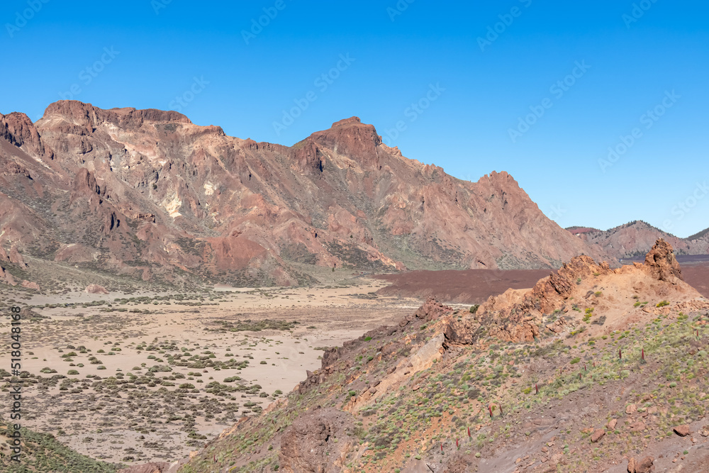 Obraz premium Panoramic view on Roque del Almendro, El Sombrero in volcano Mount Teide National Park, Tenerife, Canary Islands, Spain, Europe. Volcanic barren desert landscape. Scenic hiking trail on sunny day