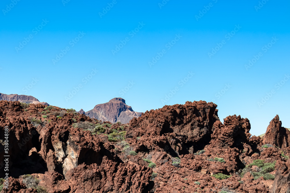 Panoramic view on mount El Sombrero in volcano Mount Teide National Park, Tenerife, Canary Islands, Spain, Europe. Volcanic barren desert landscape. Hiking trail on sunny day. Marsian rock formation