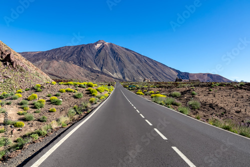Scenic mountain road leading to volcano Pico del Teide, Mount El Teide National Park, Tenerife, Canary Islands, Spain, Europe. Volcanic dry landscape. Road trip on a sunny summer day. Freedom vibes