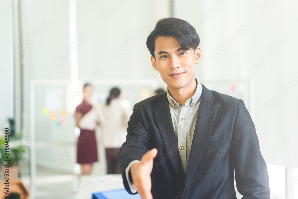 Point of view portrait asian adult businessman greeting handshake for deal to partnership or recruitment job at indoors office Point of view portrait asian adult businessman greeting handshake for deal to partnership or recruitment job at indoors office