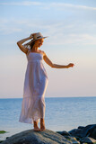 Carefree woman on seashore at sunset