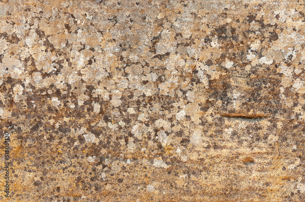 Ancient stone wall with natural patterns and multi-colored spots and scratches. Textured stone background made of natural ancient stone. Ancient stone wall with natural patterns and multi-colored spots and scratches. Textured stone background made of natural ancient stone.