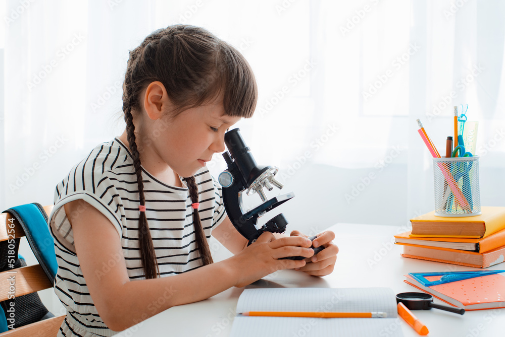 School girl with microscope for school education at home School girl with microscope for school education at home