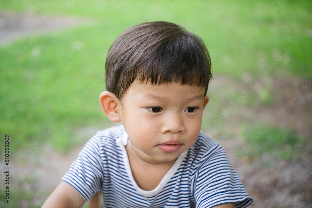 Adorable asian boy sitting and smile on green grass.Happiness boy on outdoor. Adorable asian boy sitting and smile on green grass.Happiness boy on outdoor.