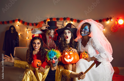 Happy adult friends in spooky costumes posing for funny group photo Fototapeta