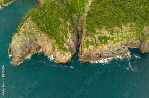 Aerial view of sheer cliffs and wave-cut canyon on rocky coastline photo