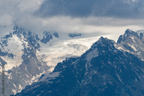Beautiful snow covered mountains with in the fog and dramatic clouds. © Inga Av