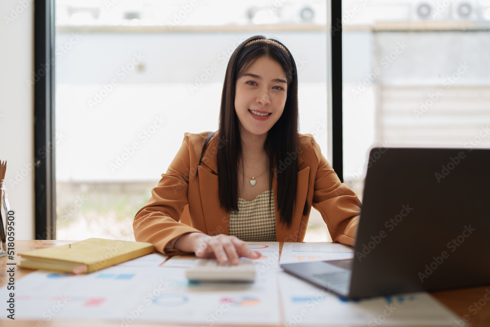 Attractive Asian business woman working with a laptop to audit financial at office. Account concept. Attractive Asian business woman working with a laptop to audit financial at office. Account concept.