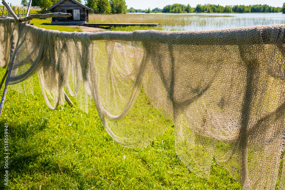Φωτογραφία A summer rural landscape, hanging drying fishing nets in the fresh air on the shore of the lake