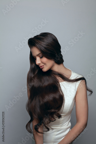 Glamorous young woman brunette with long dark healthy shiny hairstyle standing on banner background