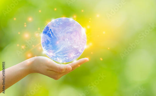 Woman hand holding earth on natural blur backgroun.