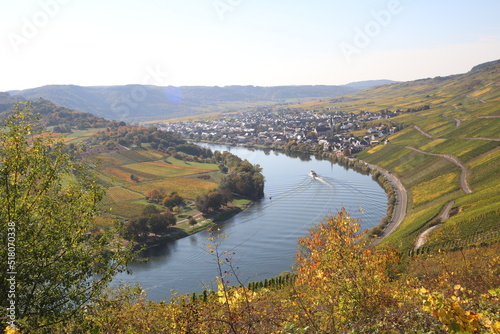 ship traveling through a bend in the Moselle river with vineyard in fall colors on both sides