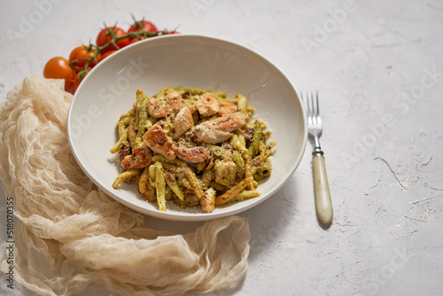 A delicious grilled chicken and pasta dumplings with pesto. Dinner on a white plate