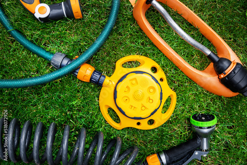 lawn and garden watering equipment. sprinklers and nozzles on grass background. top view
