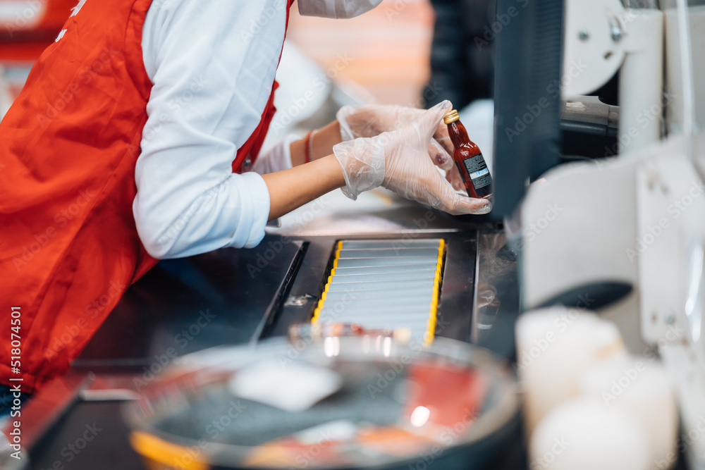 A woman reads the barcode at checkout machine in supermarket