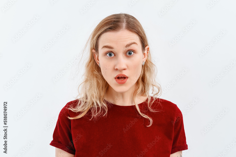 Close up photo of beautiful young woman worried, confused, wears red t shirt. Indoor studio shot on white background Close up photo of beautiful young woman worried, confused, wears red t shirt. Indoor studio shot on white background