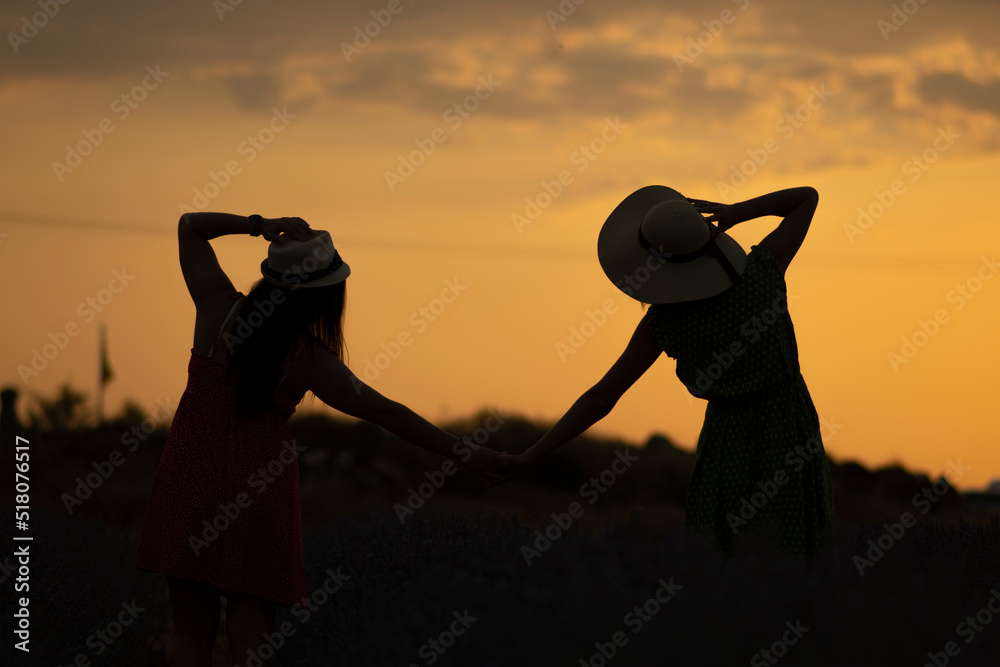 TWO GIRLS HOLDING HANDS IN A SUNSET Stock Photo | Adobe Stock