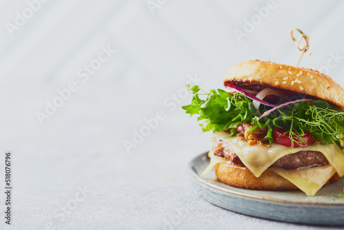 Two burgers with veal cutlet and herbs on wooden cutting board