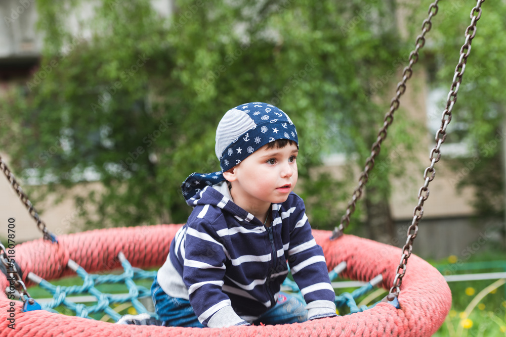 Little baby boy riding on a swing Little baby boy riding on a swing