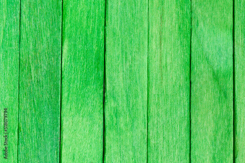 Green wooden planks arranged vertically. Textured boards painted green. Bright wooden background. Vivid Green Wooden Texture Background.