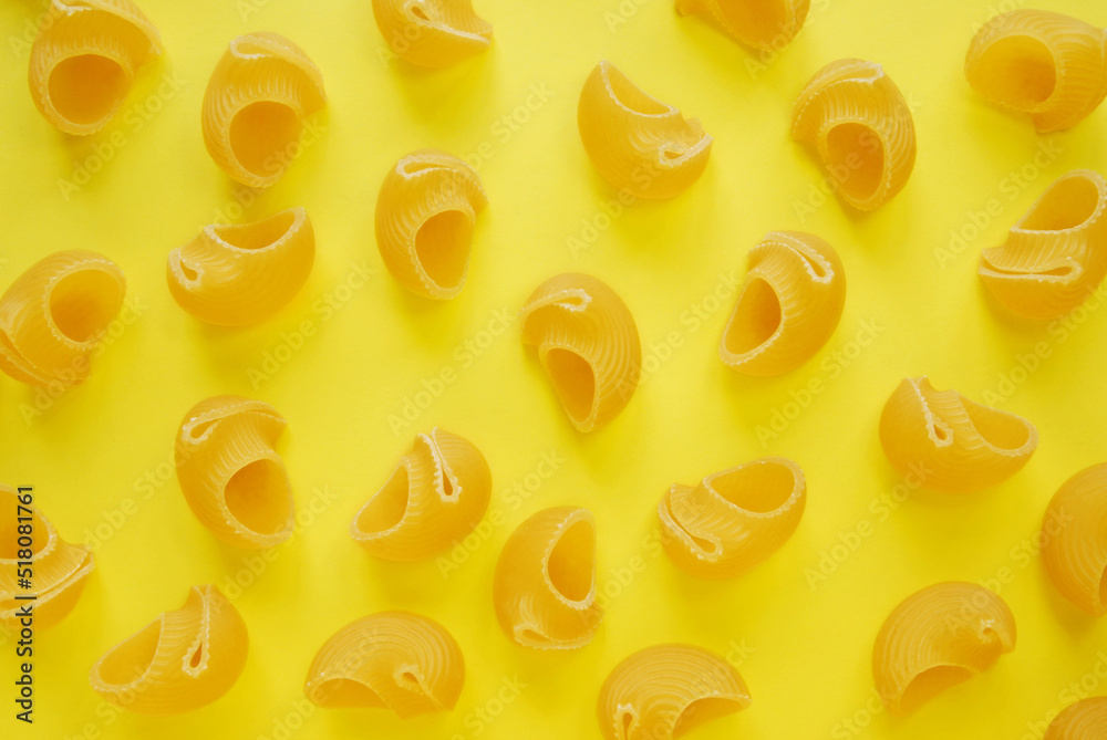 Pasta elbow macaroni on clean yellow background, a top view of a group of scattering pasta on yellow background Pasta elbow macaroni on clean yellow background, a top view of a group of scattering pasta on yellow background