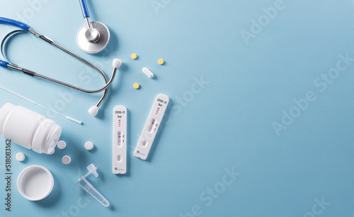 Covid-19 rapid antigen test, stethoscope and medicine on blue background. Worldwide coronavirus epidemic concept..