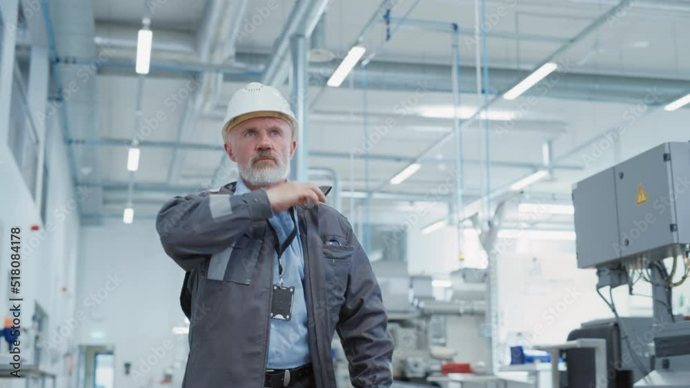 Portrait of a Middle Aged, Successful Male Engineer Putting On a White Hard Hat and Safety Glasses, While Walking at Electronics Manufacturing Factory. Heavy Industry Specialist Posing for Camera. Portrait of a Middle Aged, Successful Male Engineer Putting On a White Hard Hat and Safety Glasses, While Walking at Electronics Manufacturing Factory. Heavy Industry Specialist Posing for Camera.