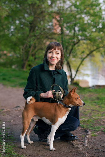 Woman with Basenji dog in nature