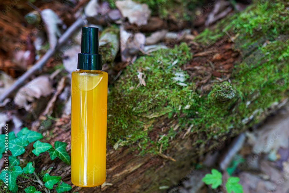 Bottle with essential oil on tree natural background. Space for text Bottle with essential oil on tree natural background. Space for text