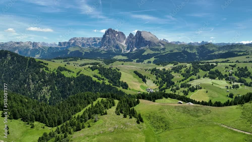 Aerial view of Seiser Alm plateau with traditional wooden mountain cottages on the meadows in Dolomites mountains in Italy. Morning drone shot of idyllic Alpe di Suisi blooming meadow in South Tyrol. Aerial view of Seiser Alm plateau with traditional wooden mountain cottages on the meadows in Dolomites mountains in Italy. Morning drone shot of idyllic Alpe di Suisi blooming meadow in South Tyrol.