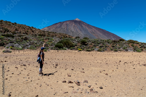 Woman on La Canada de los Guancheros dry desert plain with view on volcano Pico del Teide, Mount El Teide National Park, Tenerife, Canary Islands, Spain, Europe. Hiking to Riscos de la Fortaleza photo