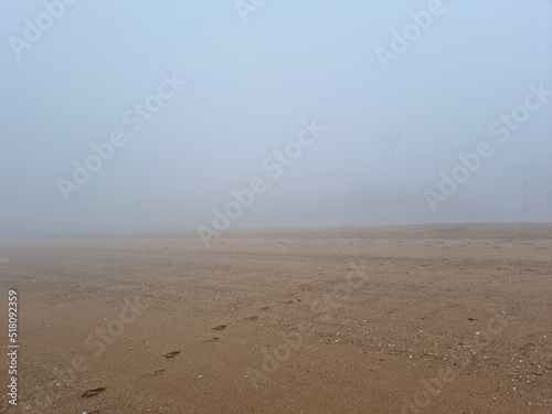 A landscape of a misty beach sandy beach
