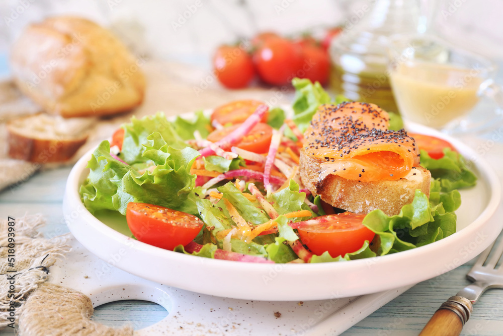 Healthy food. Lettuce salad with red fish, raw vegetables and olive oil. Red fish sandwich with rye bread, poppy seeds and mustard sauce Healthy food. Lettuce salad with red fish, raw vegetables and olive oil. Red fish sandwich with rye bread, poppy seeds and mustard sauce