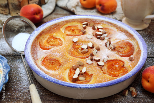 Apricot clafoutis (flan) with almonds, icing sugar dressing and cup of mint tea