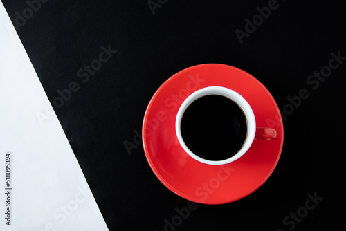 白と黒の紙の上の赤いコーヒーカップのコーヒー