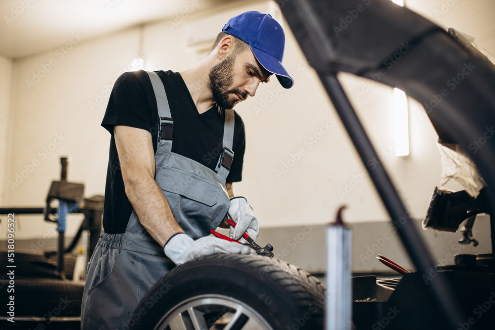 Repairman at car service changing tires