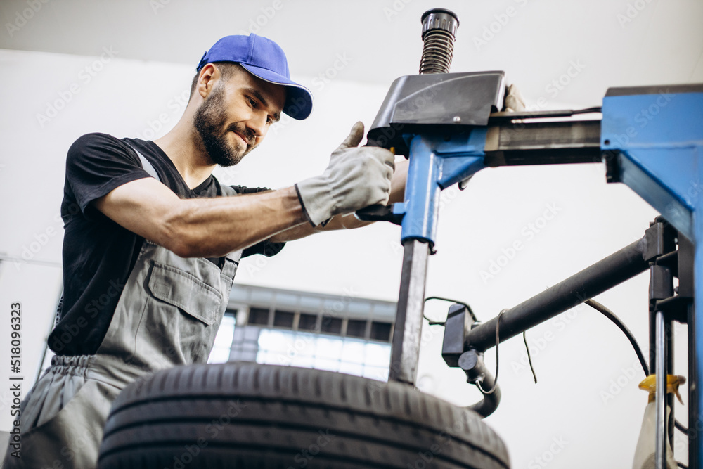 Repairman at car service changing tires