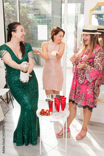 two women customers and the owner of the atelier celebrate the purchase of dresses