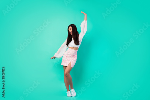 Full size portrait of overjoyed positive indonesian person enjoy dancing clubbing isolated on turquoise color background