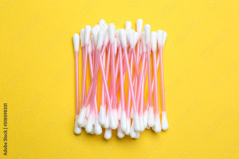 Heap of cotton buds on yellow background, top view Heap of cotton buds on yellow background, top view