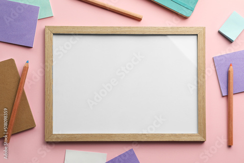 Blank white board with stationery on light pink background, flat lay. Space for text