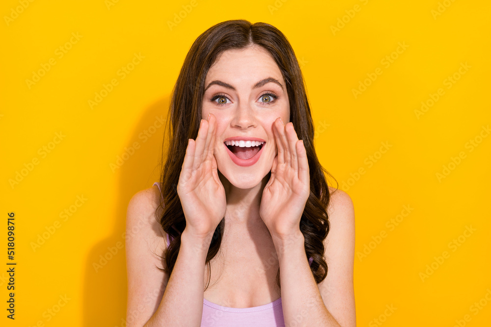 Portrait of positive person hands near open mouth say scream isolated on yellow color background Portrait of positive person hands near open mouth say scream isolated on yellow color background