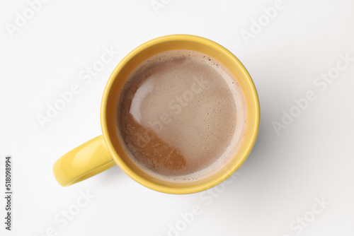 Yellow mug of freshly brewed hot coffee on white background, top view