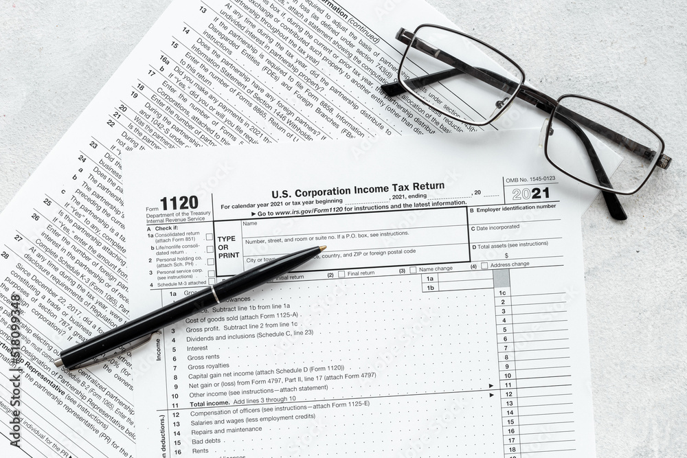 US individual tax form with pen and glasses on businessman table US individual tax form with pen and glasses on businessman table