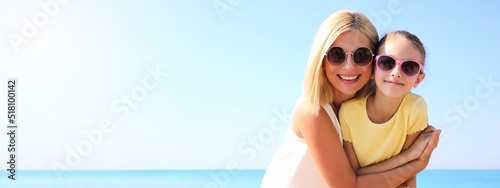Mother and daughter at beach, space for text. Banner design
