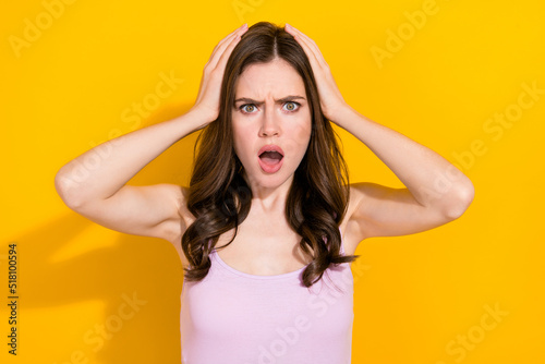 Portrait of impressed unsatisfied person arms head open mouth stare speechless isolated on yellow color background