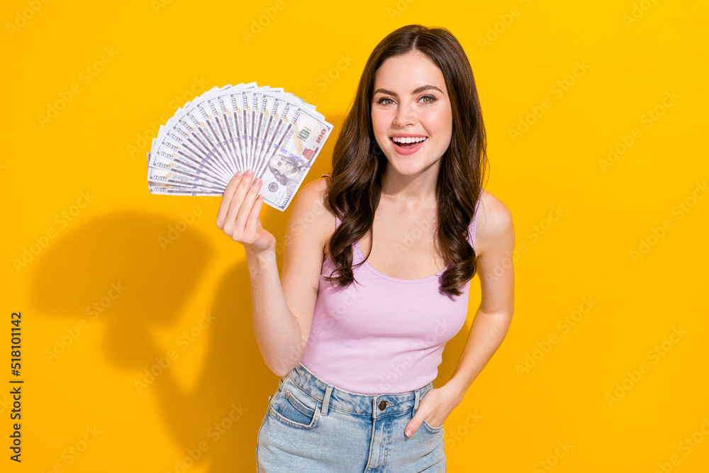 Portrait of cheerful nice lady hold demonstrate usd banknotes isolated on yellow color background Portrait of cheerful nice lady hold demonstrate usd banknotes isolated on yellow color background